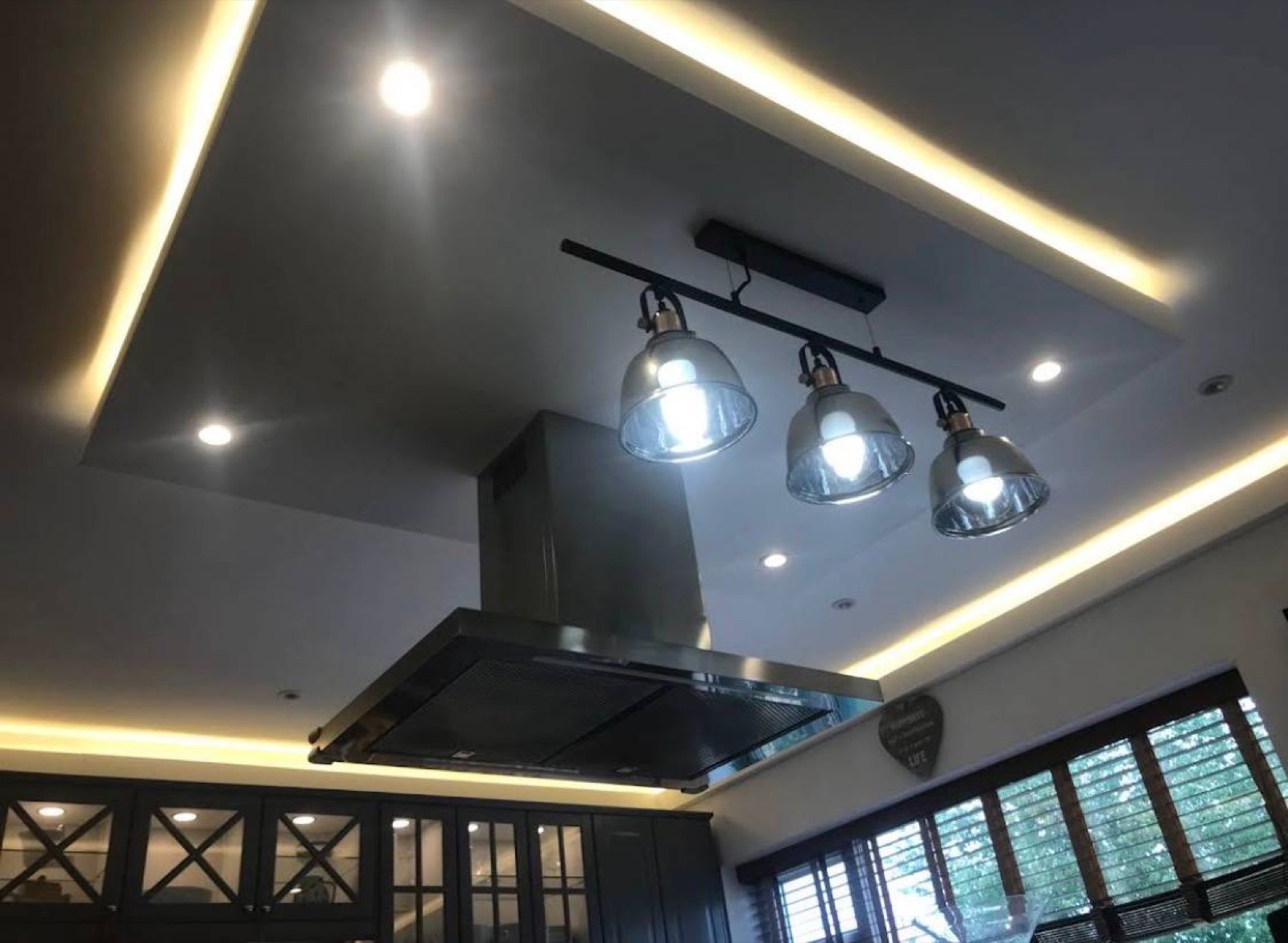 Modern kitchen with recessed LED ceiling lights and under-cabinet lighting